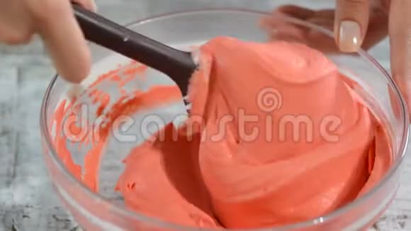 手搅拌粉红色奶油与混合碗视频的预览图