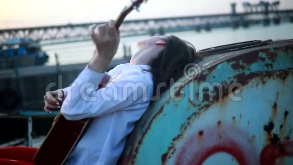 女人撒谎弹吉他在旧船上唱歌视频的预览图