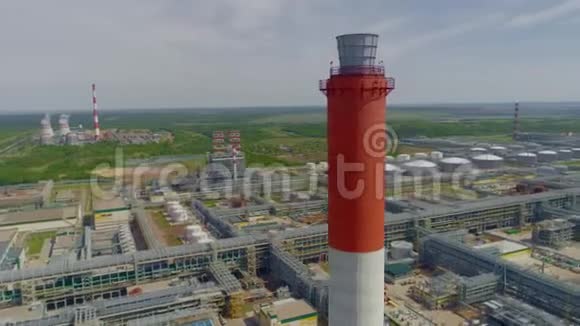 炼油厂综合大楼的红白色烟囱有管道的鸟瞰图视频的预览图