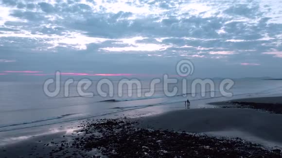 日落时分幸福的家庭漫步在风景秀丽的海滨视频的预览图