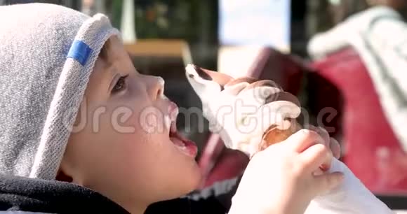 可爱的小男孩在蛋筒里舔冰淇淋视频的预览图