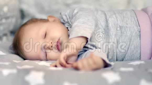 柔软的小可爱的蹒跚学步的孩子在舒适的床上睡觉在家中中镜头视频的预览图