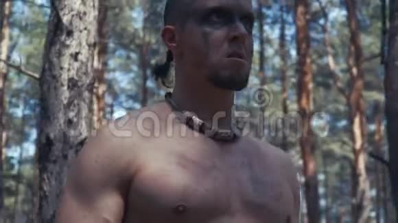 一个满脸黑漆的野蛮人站在树林里闭上嘴视频的预览图
