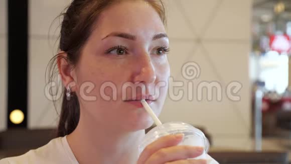 年轻女子的肖像是在快餐店喝麦秆奶昔视频的预览图