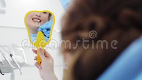 女人看着镜子从样本中选择牙齿颜色视频的预览图