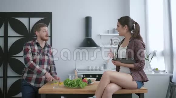 饮食计划快乐的男人从新鲜蔬菜和蔬菜中准备美味的健康沙拉女孩坐在桌子上视频的预览图
