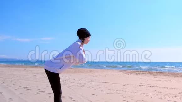 女人倾斜在沙滩上的腿伸展户外运动训练瑜伽视频的预览图