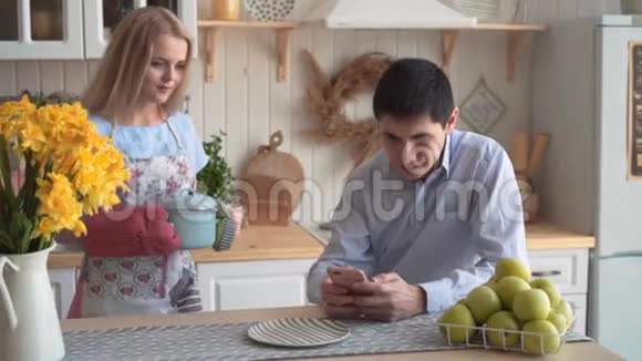 一个年轻的女人做饭她的男朋友闻她做的东西他喜欢视频的预览图