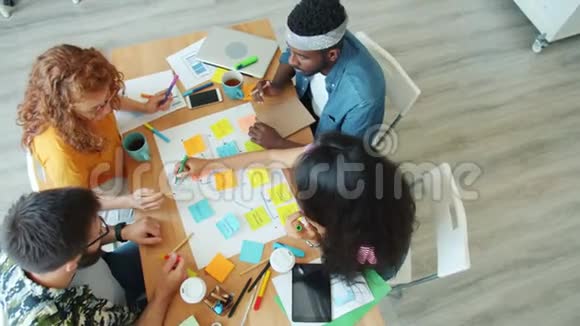 年轻有创造力的男女在办公室里分享想法制作纸卷视频的预览图