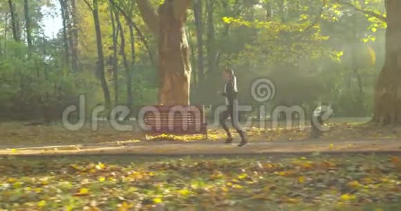 健身女孩在城市公园的晨光中跑步视频的预览图