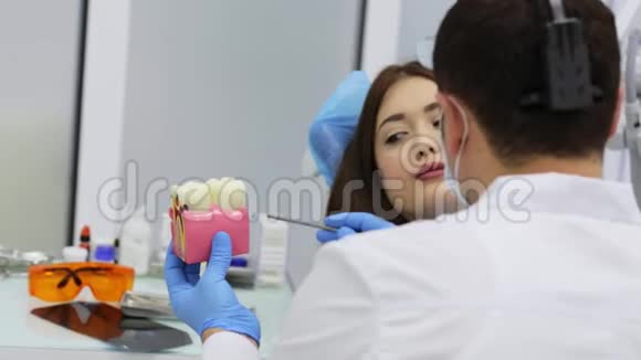 年轻女性看牙医听咨询看牙模视频的预览图