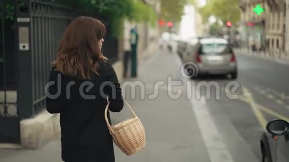 街上女人带着柳条篮子走路的慢镜头视频的预览图
