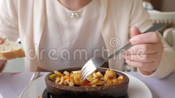 面目全非的女人正在吃炒热虾与蔬菜在粘土碗特写菜视频的预览图