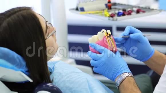 女士正在看牙模与牙腔在牙医手中咨询视频的预览图