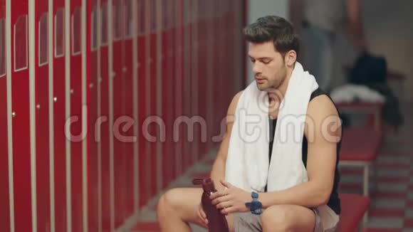 疲惫的运动员在更衣室里喝水视频的预览图