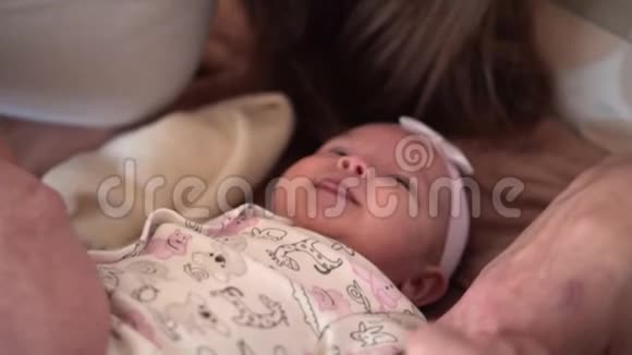 家人笑在床上哪里的小女儿特写微笑拥抱亲吻幸福的家庭视频的预览图