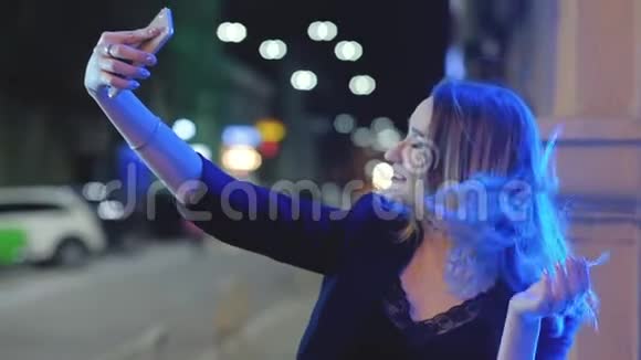 派对女孩自拍智能手机夜城灯视频的预览图