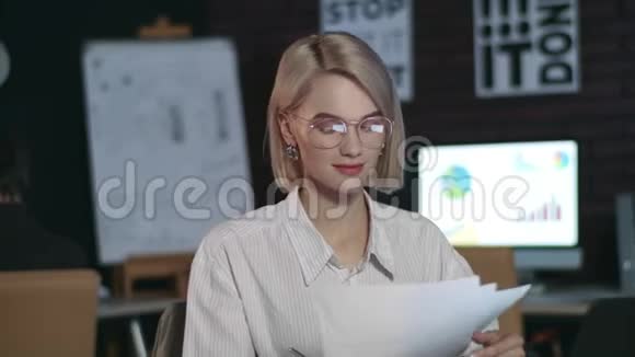 性格开朗的商务女性在办公室里用笔记本电脑工作特写女孩检查报纸视频的预览图