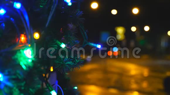 圣诞树的近枝上装饰着明亮的花环在夜晚发光人工杉树视频的预览图