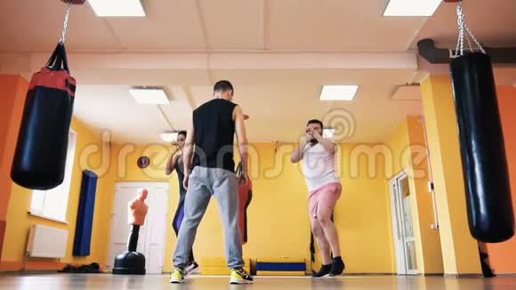 一个胖子和苗条的女人在健身房里有私人教练在拳击比赛中打火车健康和健身练习与练习视频的预览图
