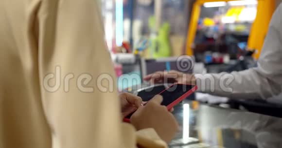 年轻女性使用智能手机支付非接触式交易机器视频的预览图
