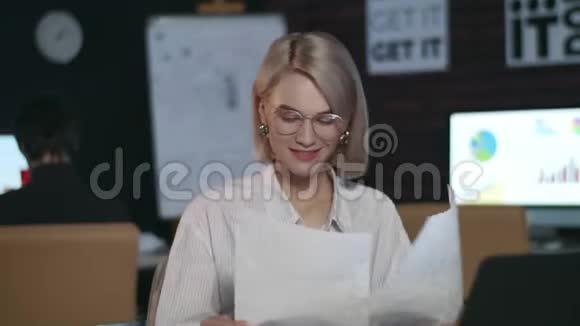 满意的商务女性在黑暗的办公室前笔记本电脑上享受好的结果视频的预览图