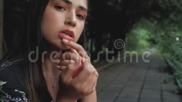 一个西班牙黑发女孩的肖像手里拿着一个压扁的普通话脸上涂着普通话4k4k视频视频的预览图