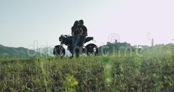 一对夫妇骑着一辆黑色摩托车在迷人的风景中享受在一起的时光视频的预览图