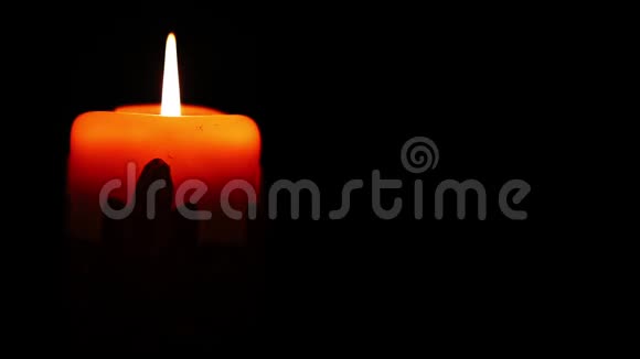 在黑暗的房间里燃烧着装饰物的圣诞蜡烛温暖的黄色蜡烛在黑暗中轻轻燃烧视频的预览图