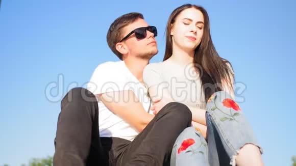 浪漫的幸福夫妇坐在绿色的草地上对抗天空夫妻信任爱和幸福的理念全垒打视频的预览图