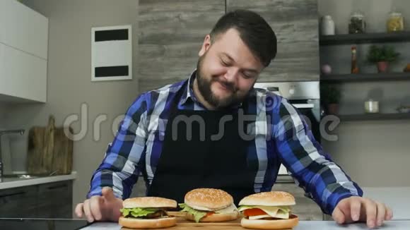 一个有趣的家伙对他做的汉堡包很满意面带微笑不健康的生活方式油炸和高热量视频的预览图