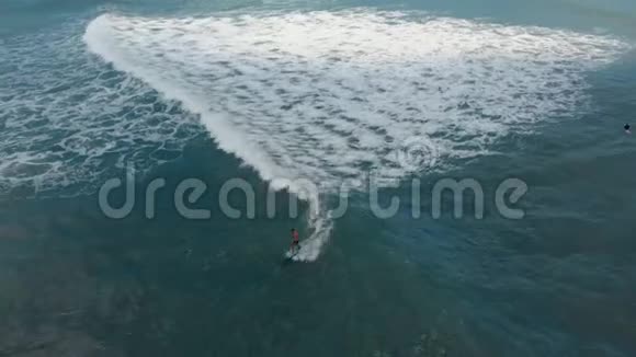 冲浪者学习如何在长板上冲浪的空中镜头视频的预览图