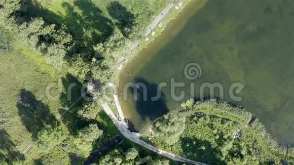 在一个绿色的小湖里人们游泳坐在岸边视频的预览图