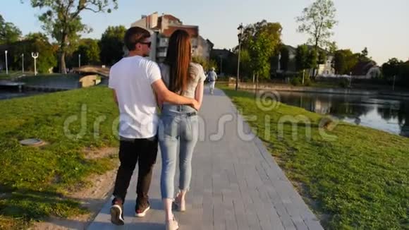 靠近美丽迷人的年轻夫妇在公园散步的后景后方户外活动全垒打视频的预览图