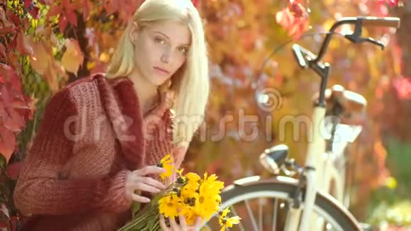 秋天的女人穿着针织毛衣留着长发的梦幻女孩秋天和树叶飘落的梦想公园里快乐的年轻女子视频的预览图