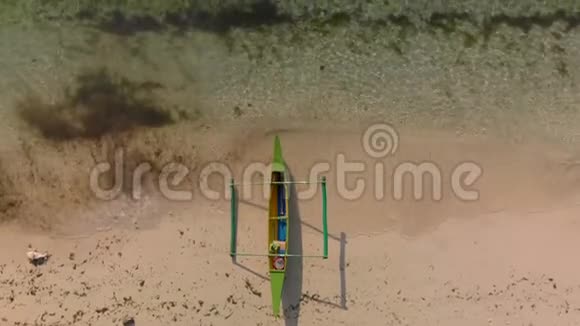 独木舟在野生沙滩上有藻类和半透明的蓝色水从上面看视频的预览图
