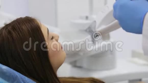 牙科医生为激光漂白牙齿的女性患者戴上防护眼镜视频的预览图