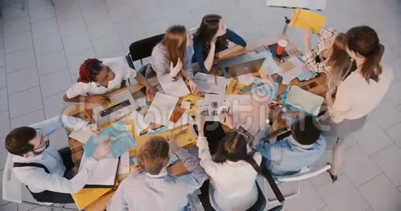 顶视幸福商务女性老板一起工作分析财务数据与年轻的公司员工在会议上视频的预览图