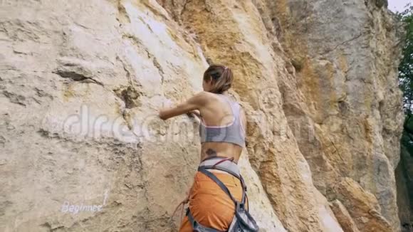 年轻健康的女性攀岩者爬上山寻找到达和抓住视频的预览图