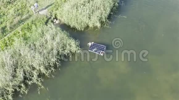 女孩在湖中漂浮时把气垫推到岸上视频的预览图