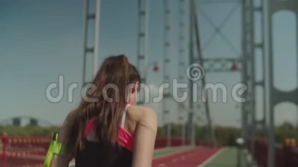 年轻女子在城市桥锻炼时跑步视频的预览图