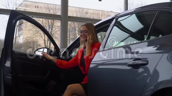 一位美女坐在汽车经销店的车里打电话视频的预览图