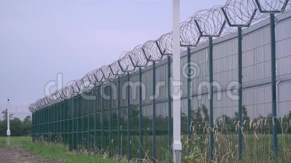 带刺铁丝网的监狱栅栏又长又高的绿色栅栏视频的预览图