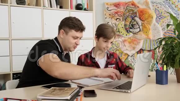 白种人的父亲用手提电脑慢动作帮助他的儿子弄清楚他的面罩视频的预览图