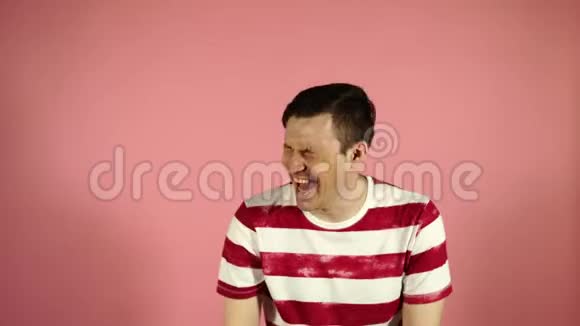 穿T恤的年轻人站在粉红色的背景上笑着视频的预览图