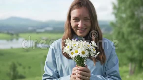 她拿着一束野花把它们拉进镜头视频的预览图