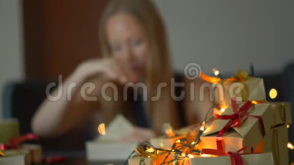 一个年轻的女人打包礼物她厌倦了在大假期前做这么多礼物疲劳的概念视频的预览图