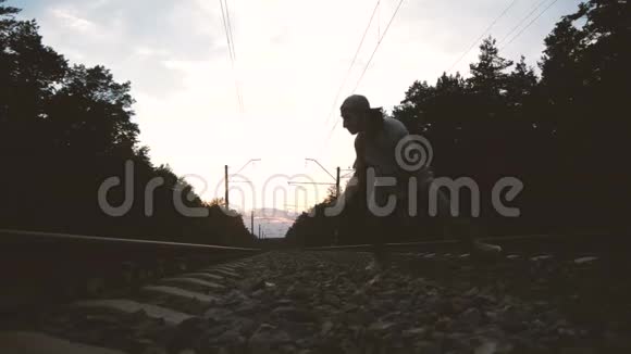 日落时分一个人在铁轨附近用手跳舞动作缓慢视频的预览图