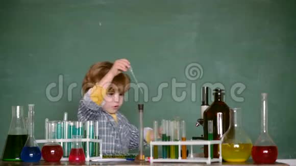 快乐微笑的小男孩在蓝墙上玩得很开心化学演示什么是化学教学学校视频的预览图