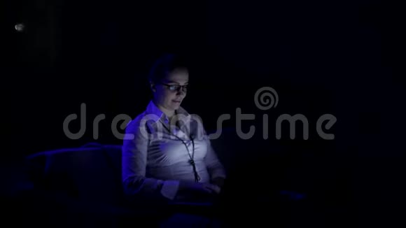 后来一个女人在笔记本电脑上工作监控眼镜里的反光视频的预览图